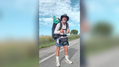 Fábio Santos caminhando em estrada rumo ao Alasca.