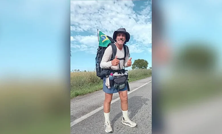 Fábio Santos caminhando em estrada rumo ao Alasca.