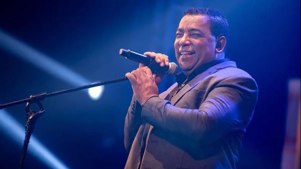 Banda Raça Negra se apresentando em um palco iluminado.