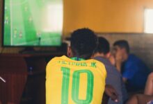 Pessoas assistindo a um jogo de futebol em um escritório.