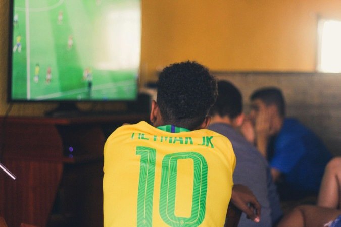 Pessoas assistindo a um jogo de futebol em um escritório.
