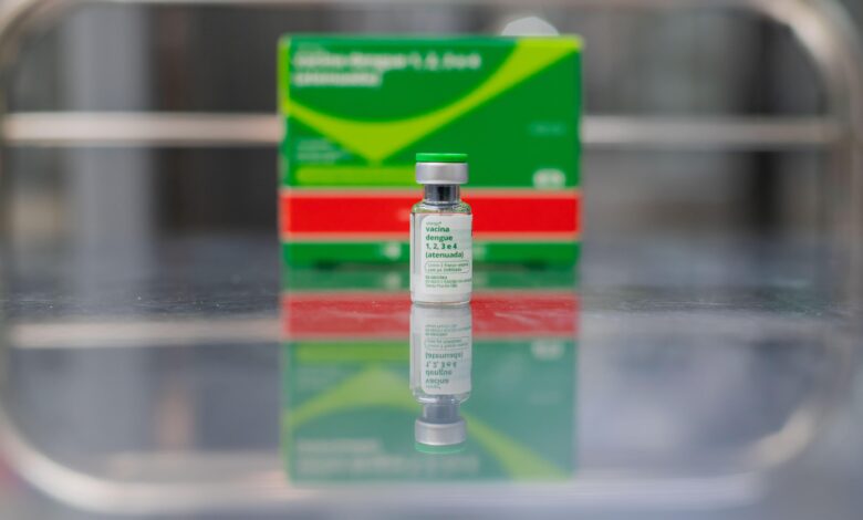 Frasco de vacina contra a dengue em fundo neutro.