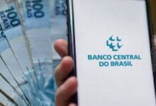 Pessoas sacando dinheiro em um caixa eletrônico.