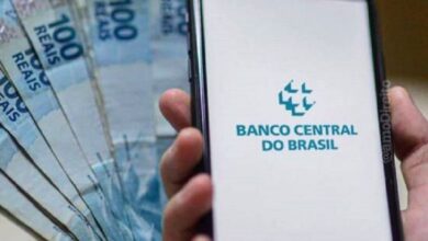Pessoas sacando dinheiro em um caixa eletrônico.