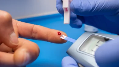 Médico com luvas coletando sangue de paciente.