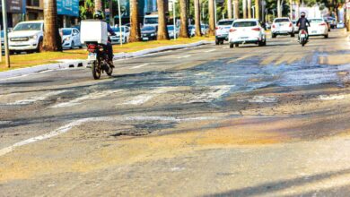 Avenida T-63 em Goiânia mostrando asfalto deteriorado.
