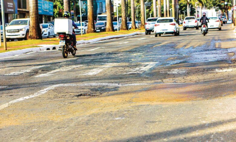 Avenida T-63 em Goiânia mostrando asfalto deteriorado.