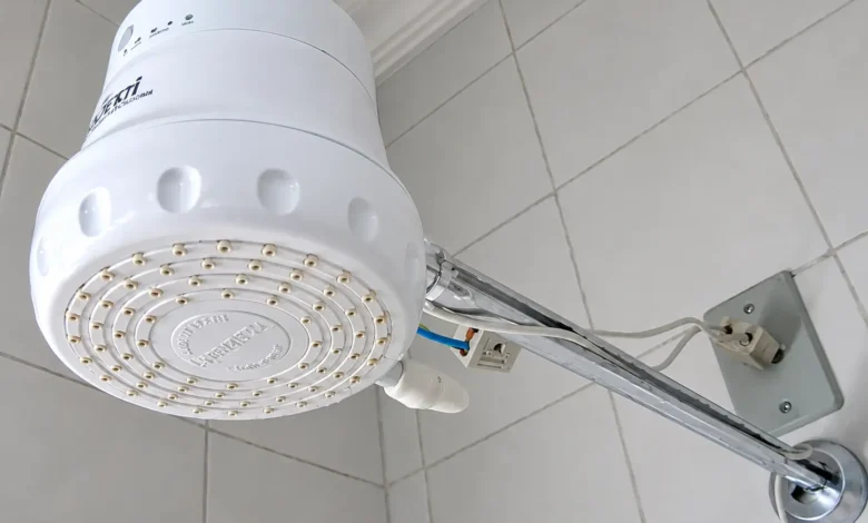 Chuveiro elétrico em funcionamento, com vapor visível.