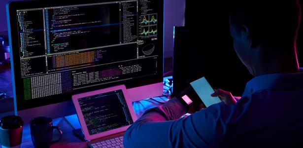 Trabalhadores em um escritório utilizando computadores com tecnologia de inteligência artificial.