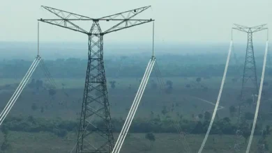 Vista de áreas agrícolas no Vale do Araguaia com instalações de energia ao fundo.