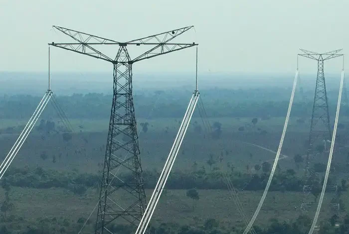 Vista de áreas agrícolas no Vale do Araguaia com instalações de energia ao fundo.