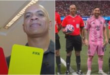 Árbitro brasileiro em ação durante uma partida de futebol.