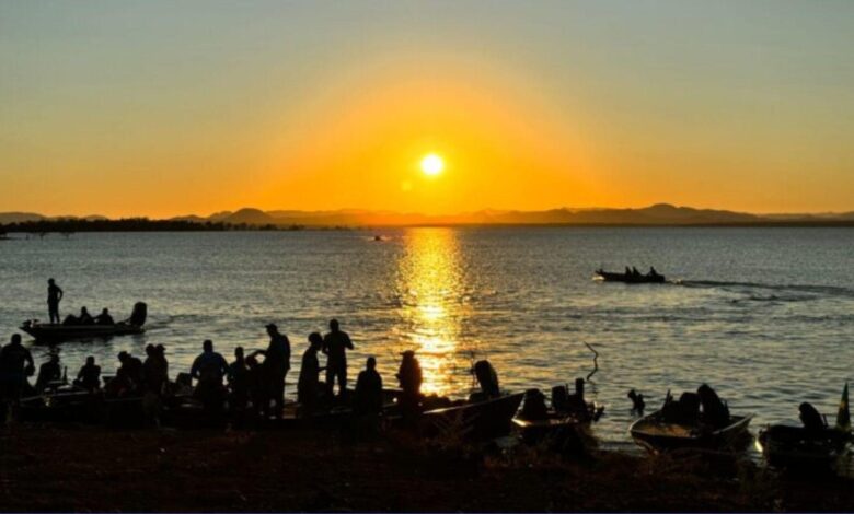 Pessoas relaxando em uma praia às margens do Rio Araguaia em um dia ensolarado.