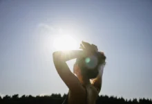 Pessoa tomando sol em parque, simbolizando a exposição solar para produção de vitamina D.