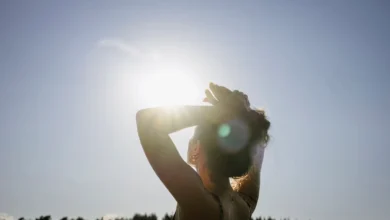 Pessoa tomando sol em parque, simbolizando a exposição solar para produção de vitamina D.