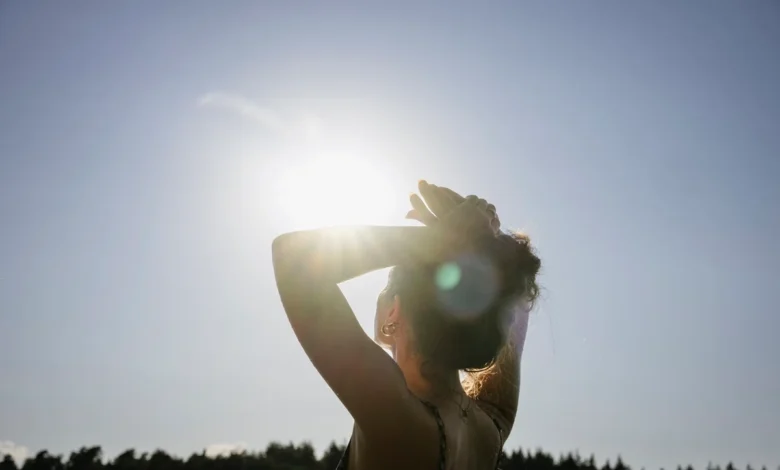 Pessoa tomando sol em parque, simbolizando a exposição solar para produção de vitamina D.