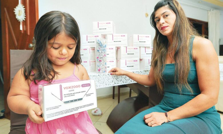 Criança sendo examinada por médico em consultório.