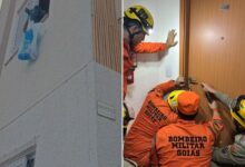 Policiais e assistentes sociais em frente a um prédio de apartamentos em Goiânia.