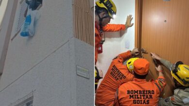 Policiais e assistentes sociais em frente a um prédio de apartamentos em Goiânia.
