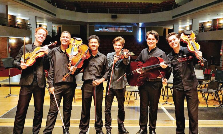 Grupo de músicos goianos se apresentando em um palco.