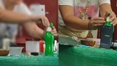 Mulher filmada colocando substância em garrafa de água.