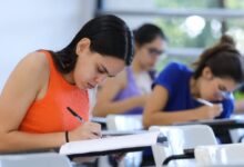 Estudantes realizando inscrição em computador.