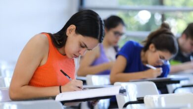 Estudantes realizando inscrição em computador.