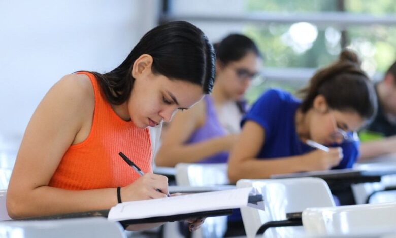 Estudantes realizando inscrição em computador.