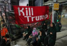Mulheres em comício pró-governo no Irã com faixa contra Donald Trump.