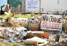 Ponto de descarte ilegal de lixo em Goiânia, com resíduos espalhados.