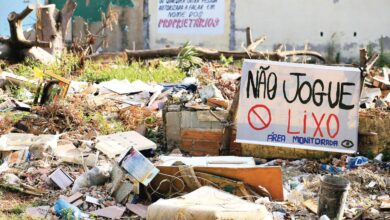 Ponto de descarte ilegal de lixo em Goiânia, com resíduos espalhados.