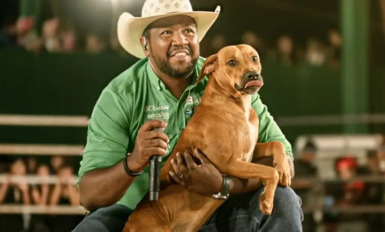 Cachorro vira-lata caramelo ao lado do locutor Zubu Max em Rialma, Goiás.