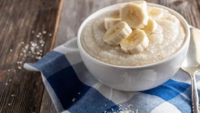 Tigela de mingau proteico com frutas e sementes em uma mesa.