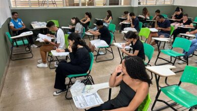 Pessoas preenchendo formulários de inscrição para curso preparatório.