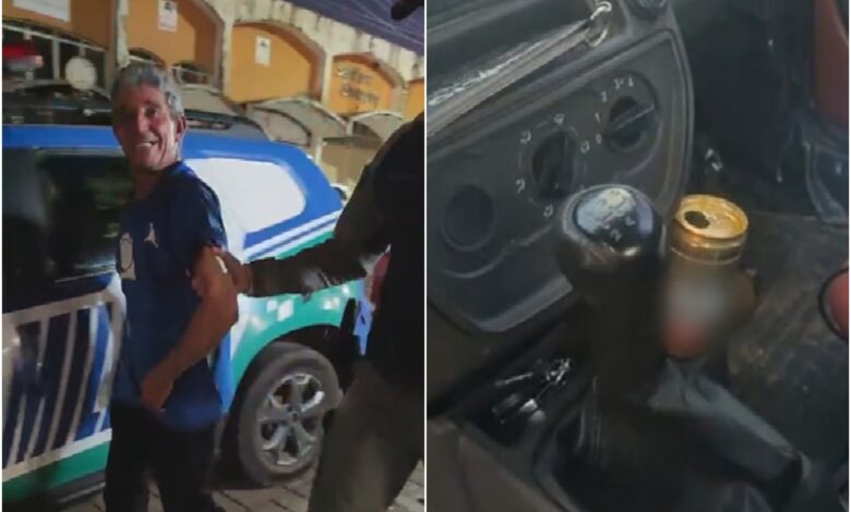 Motorista sorrindo enquanto é preso por embriaguez ao volante.