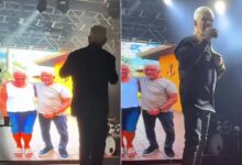 Cantor Mato Grosso emocionado em show com imagem da irmã no telão ao fundo.