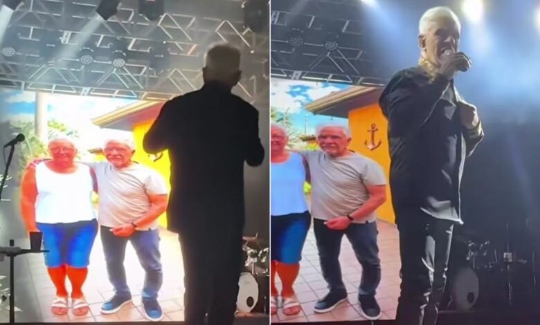 Cantor Mato Grosso emocionado em show com imagem da irmã no telão ao fundo.