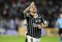 Jogadores do Corinthians em campo durante partida de futebol.