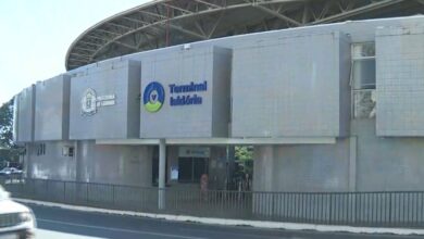 Terminal de ônibus em Goiânia com estrutura moderna e pessoas circulando.