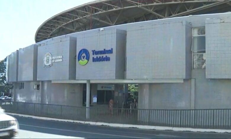 Terminal de ônibus em Goiânia com estrutura moderna e pessoas circulando.