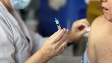 Profissional de saúde aplicando vacina em criança em UBS.