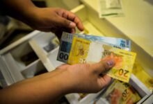 Notas de real em uma carteira, simbolizando o aumento do salário mínimo.