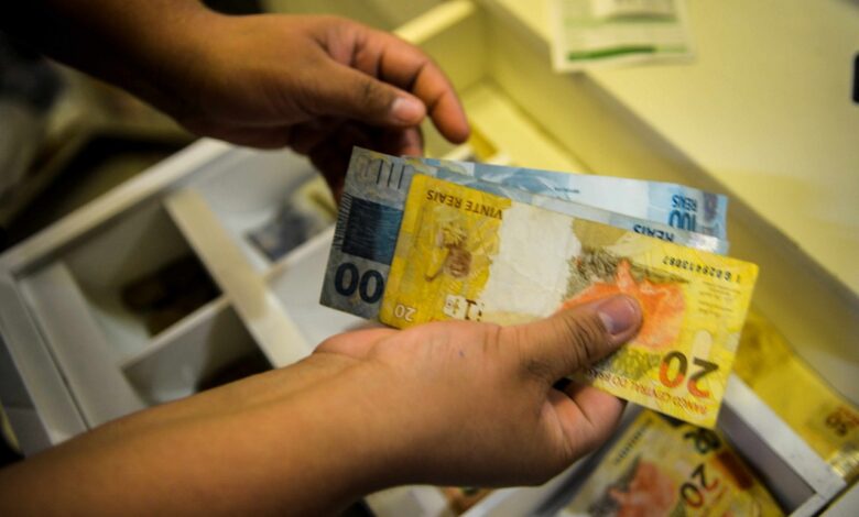 Notas de real em uma carteira, simbolizando o aumento do salário mínimo.
