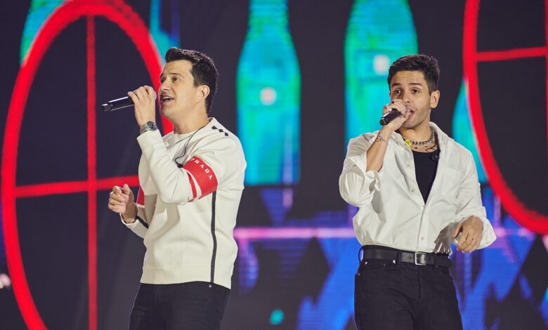 A dupla sertaneja Hugo e Guilherme se apresentando em um show ao vivo.