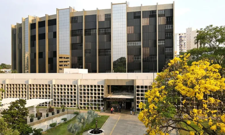 Fachada do Tribunal de Justiça de Goiás com bandeiras ao vento.