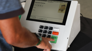 Urnas eletrônicas sendo preparadas para as eleições de 2026, destacando a nova interface e recursos de acessibilidade.