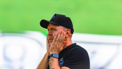 Jogadores do Goiás em campo com faixas pretas nos braços durante protesto.