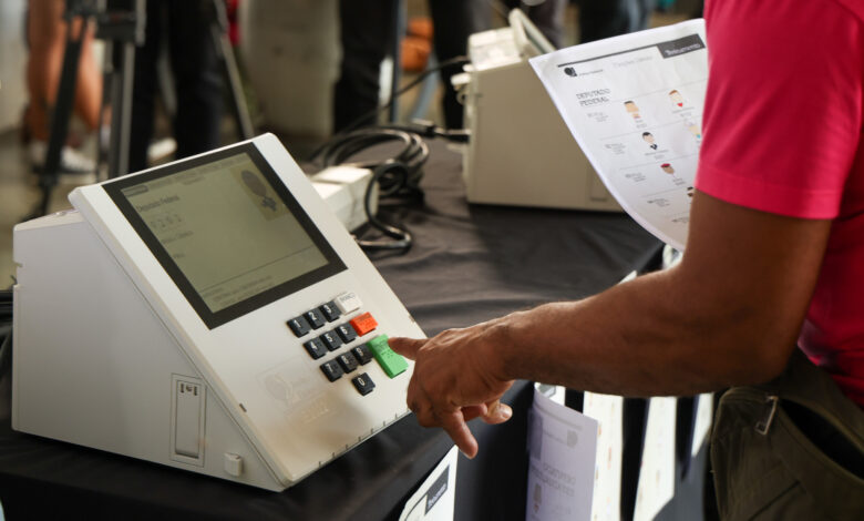 Eleitor votando em urna eletrônica.