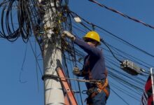 Equipe da Operação Cidade Segura removendo fios de postes em Goiânia.