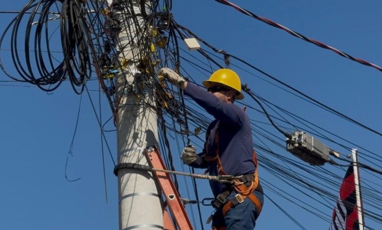 Equipe da Operação Cidade Segura removendo fios de postes em Goiânia.